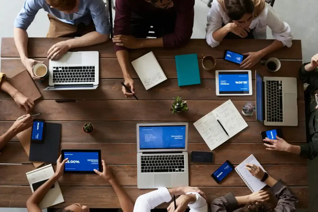 Team of professionals collaborating around a table with laptops and documents during a business planning session related to registering a company in Croatia