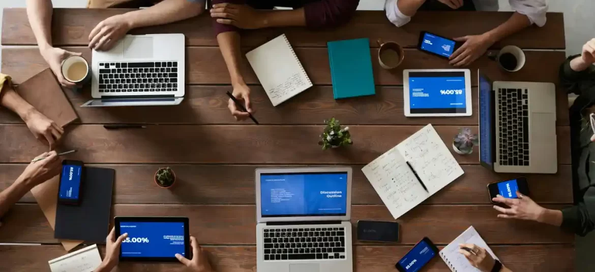 Team of professionals collaborating around a table with laptops and documents during a business planning session related to registering a company in Croatia