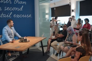 Prof. Dr. Sime Jozipovic (Founder of Mandracchio Capital) speaking at a workshop hosted by FBOA, sharing insights on common mistakes foreigners make when starting a company in Croatia, seated at a wooden table addressing an attentive audience in a modern office setting.